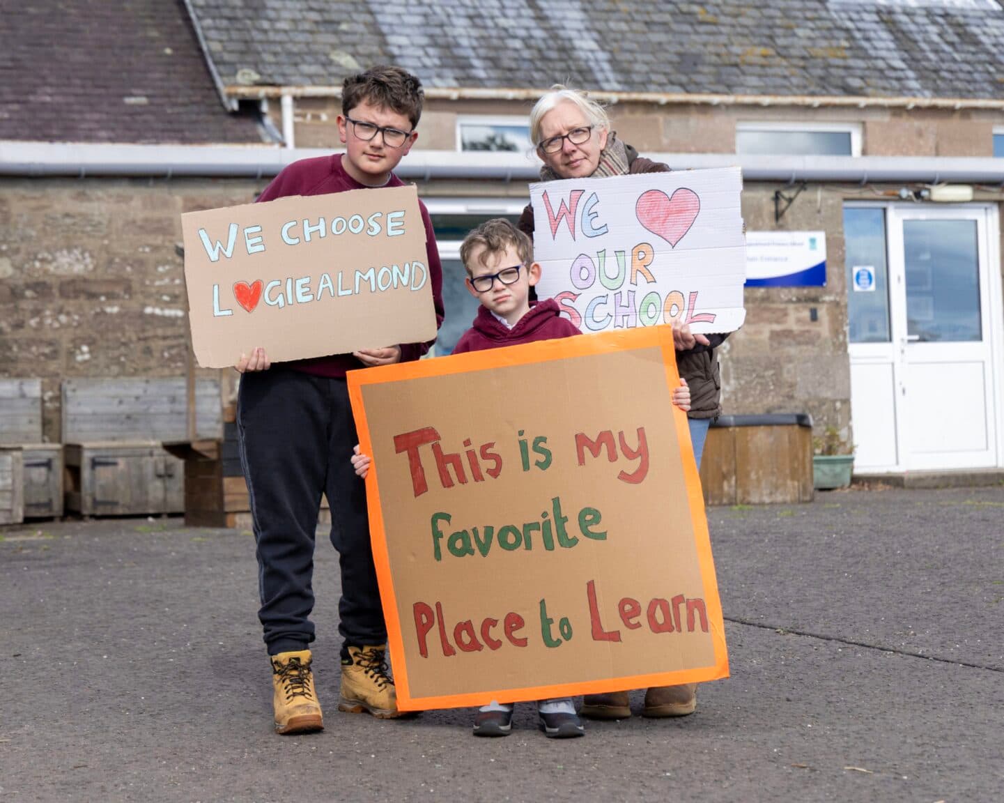 Children holding signs reading “This is my favourite place to learn”